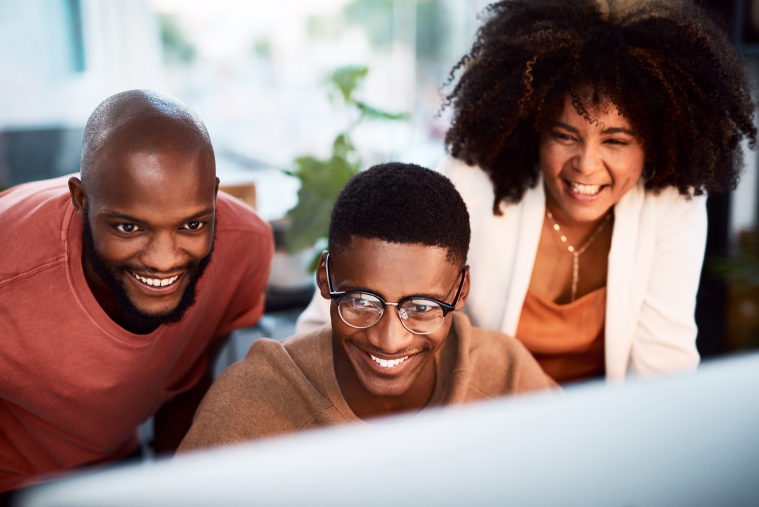 Colleagues smiling as they look at results on a screen