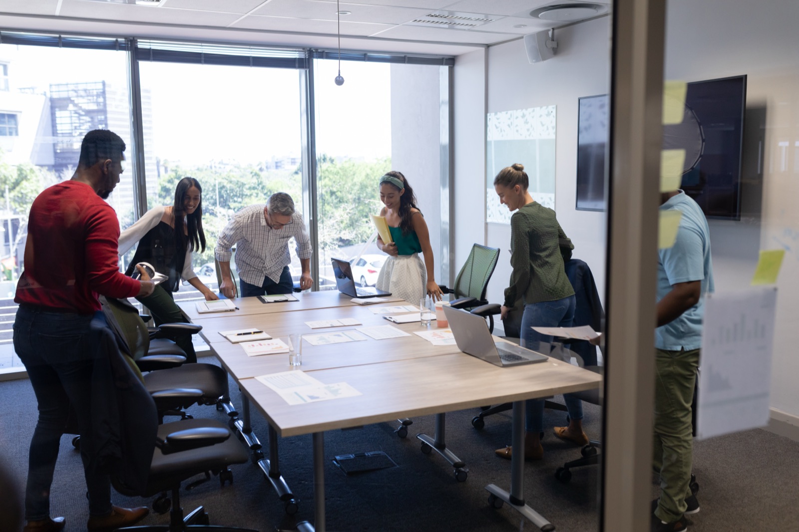 A delivery team gathered around a conference table reviewing work together in a bright office